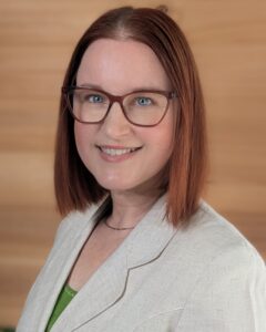 headshot of Sumara Meers in a corporate outfit wearing glasses and a beige blazer.